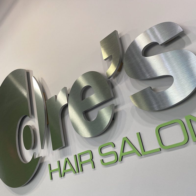 A sign that says dre 's hair salon